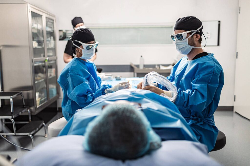 Phlébologue procède à une microphlébectomie ambulatoire sur un patient couché à la Clinique de phlébologie de Québec