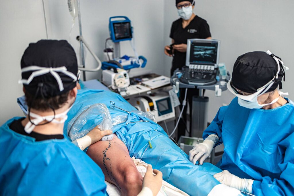 Patient couché reçoit le traitement par laser endoveineux exécuté par un phlébologue à la Clinique de phlébologie de Québec